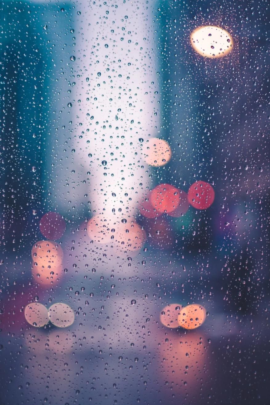 A Blurry Picture of Rain Drops on A Window with Lights in The Background — City Glass Newcastle in Kurri Kurri, NSW