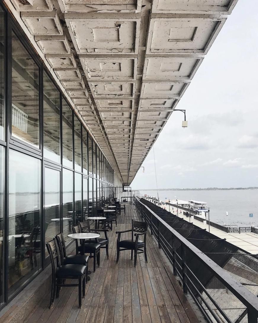 A Balcony with Tables and Chairs Overlooking a Body of Water — City Glass Newcastle in Kurri Kurri, NSW