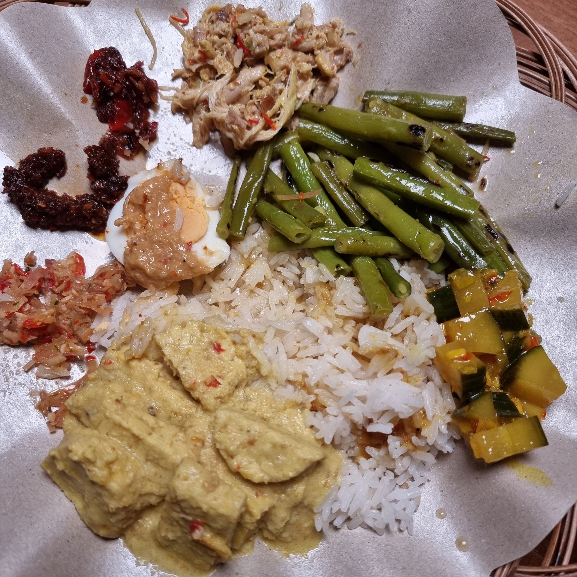 Een bord Indonesisch eten met rijst, tofu, bonen, ei en andere toppings.