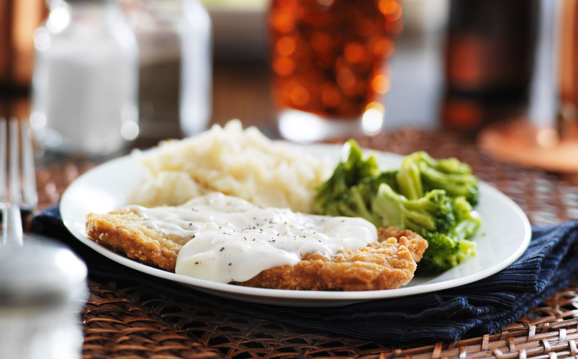 a white plate topped with chicken , gravy , mashed potatoes and broccoli .