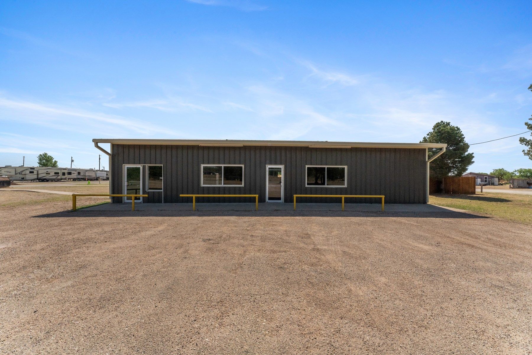 a large building with a lot of windows is sitting in the middle of a dirt field .