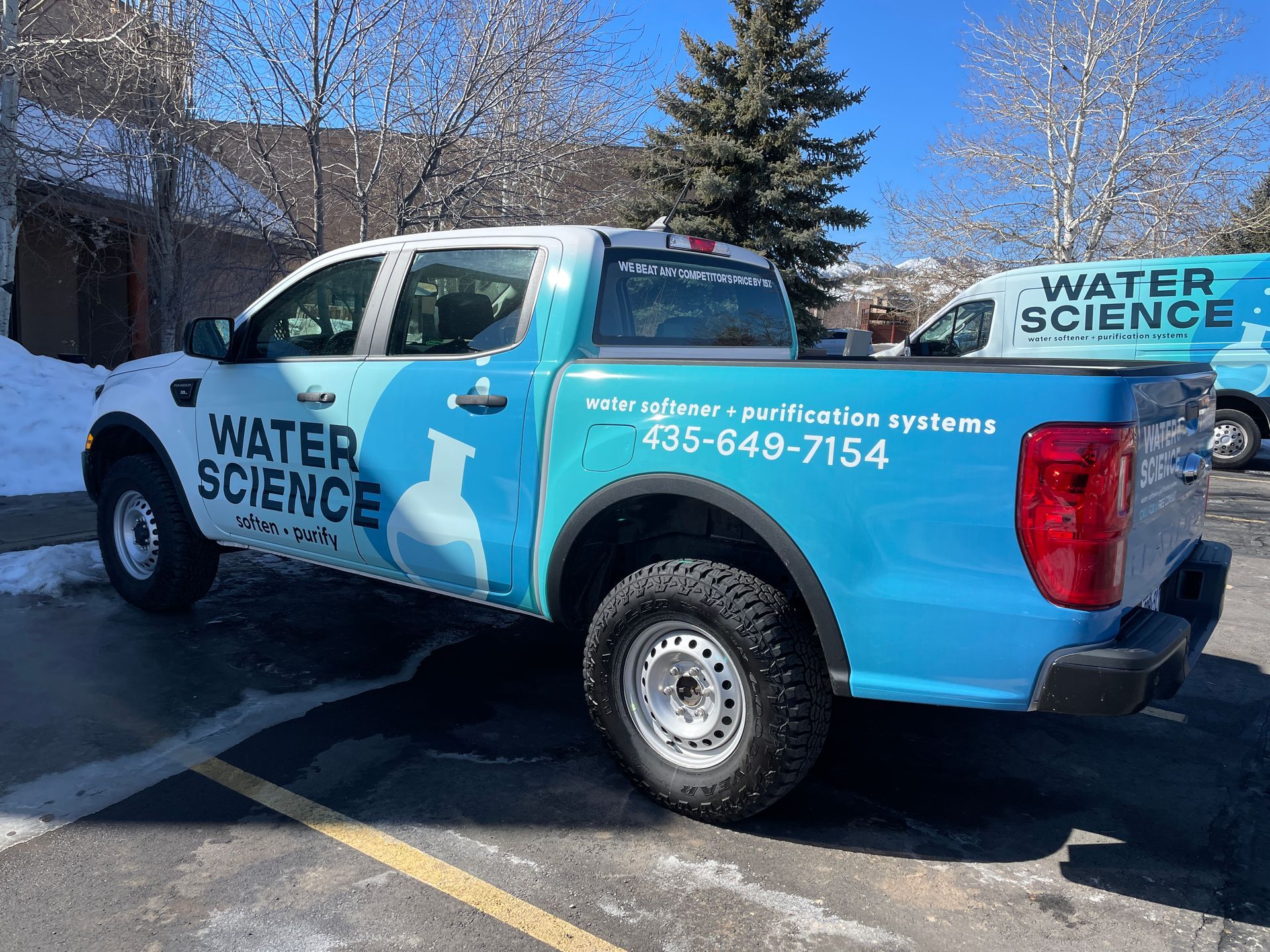 A blue and white water science truck is parked in a parking lot.