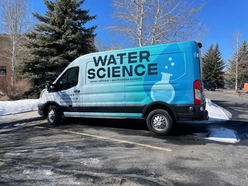 A water science van is parked in a parking lot.