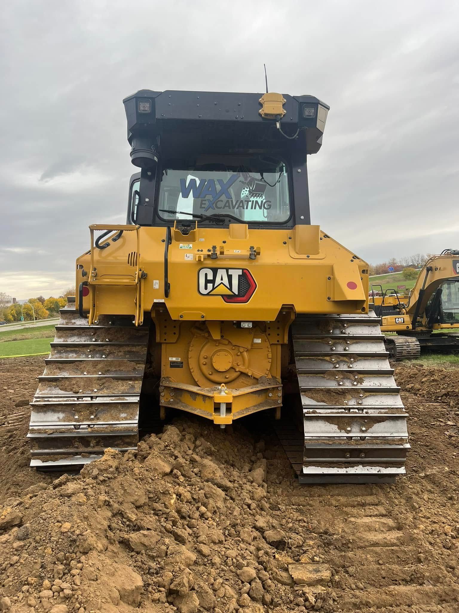 A bulldozer is sitting in the middle of a dirt field.