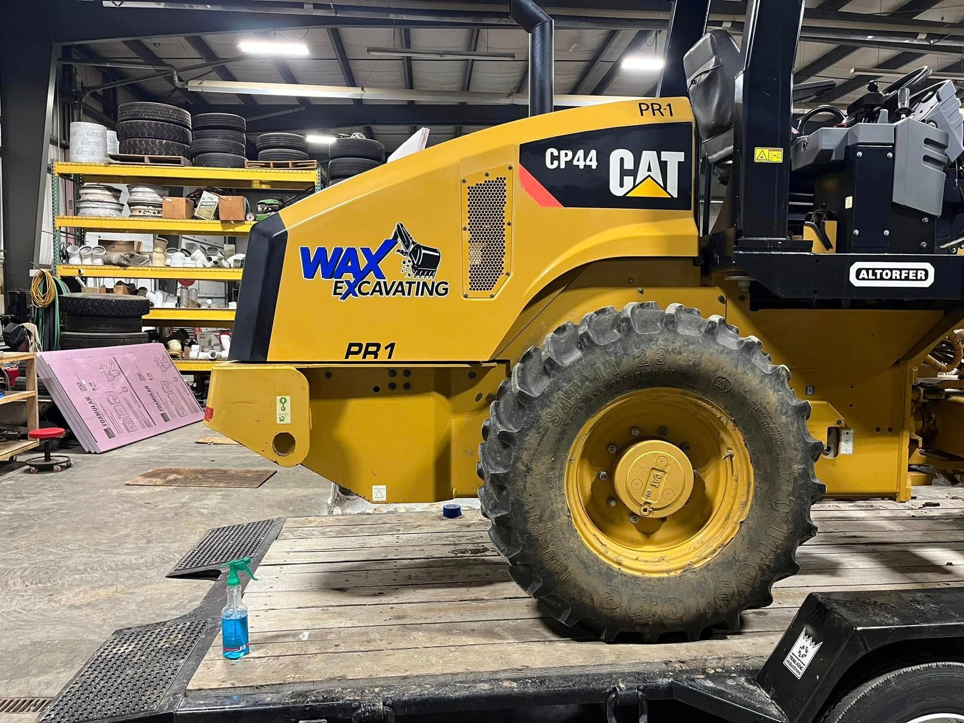 A yellow cat machine is parked in a garage
