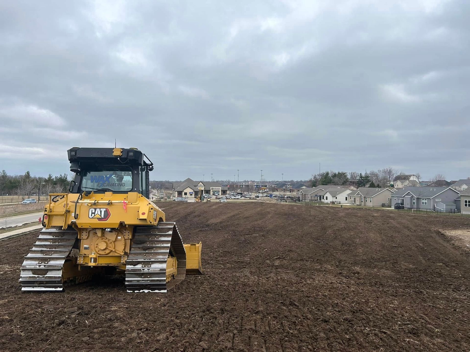 A bulldozer is sitting in the middle of a dirt field.