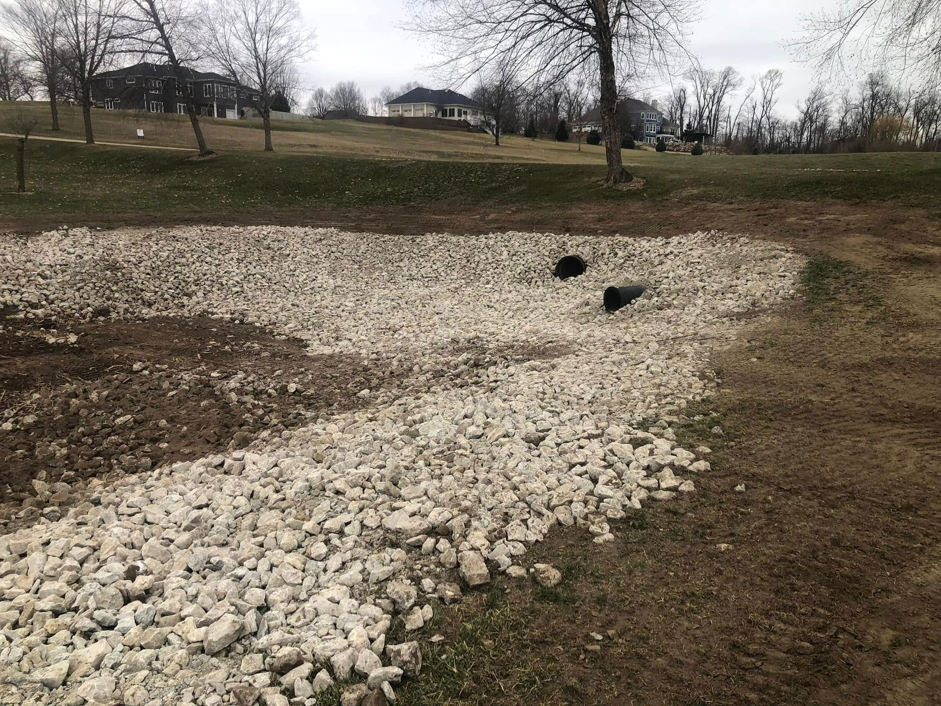 A pile of gravel is sitting in the middle of a field.