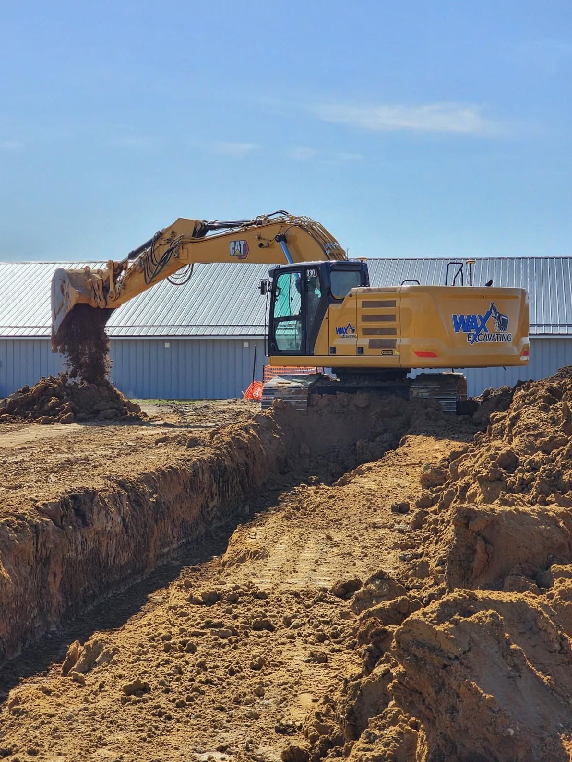 A large rock wall is sitting in the middle of a dry grass field.