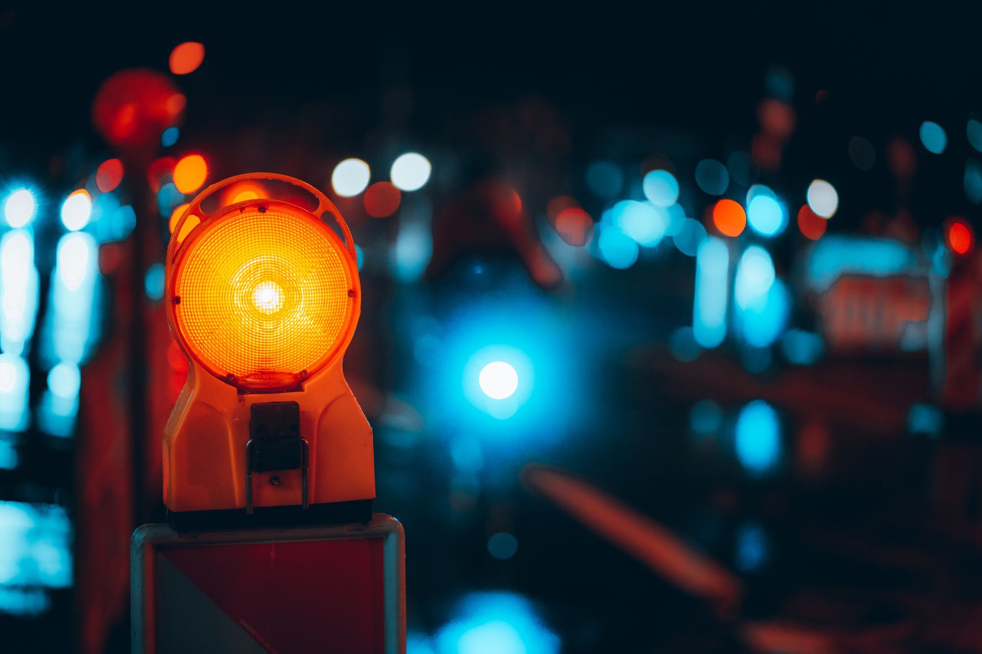 Orange flashing construction barricade light at night.