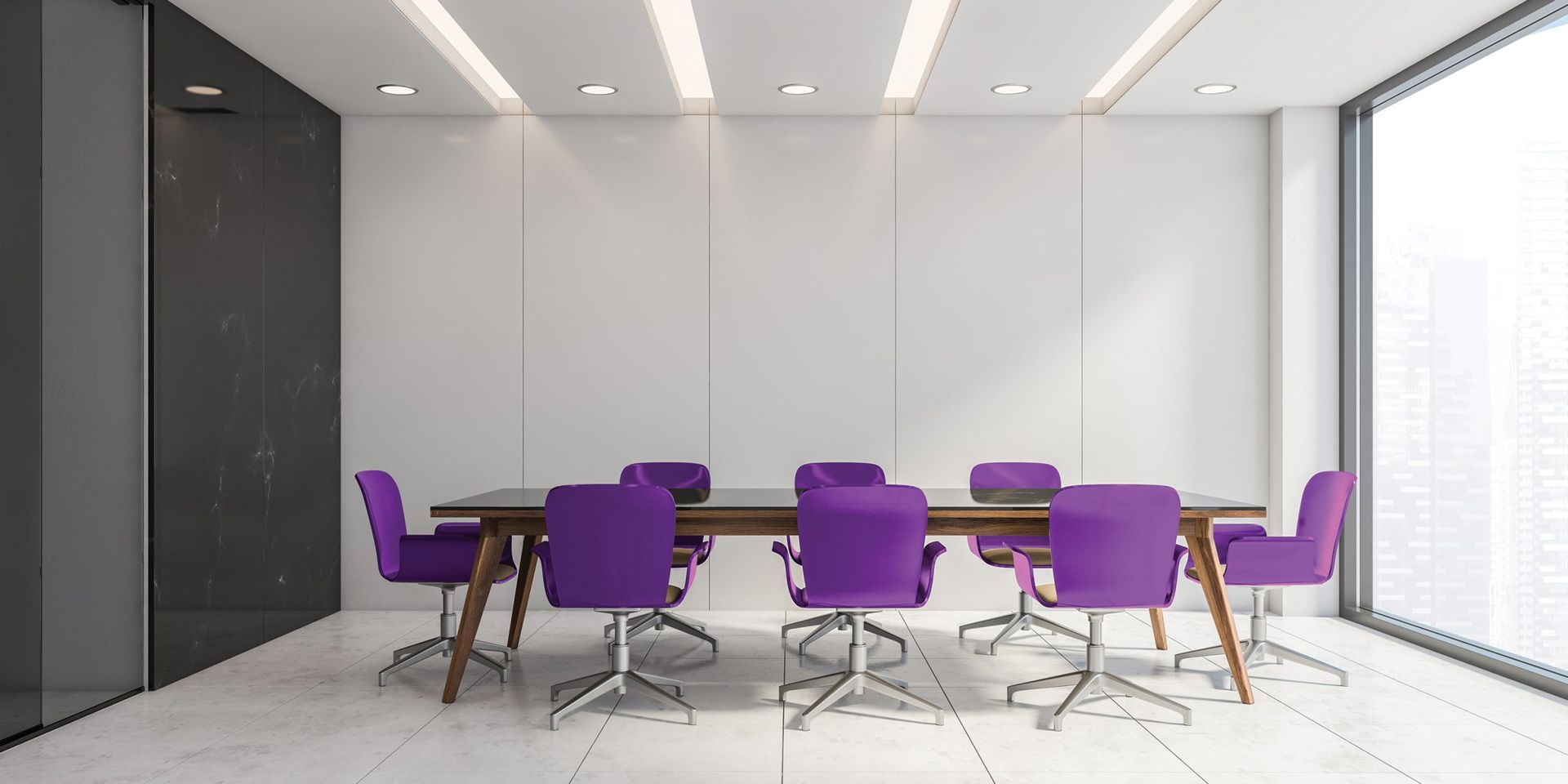 A modern conference room with a long wooden table and purple chairs. Large windows and white walls.