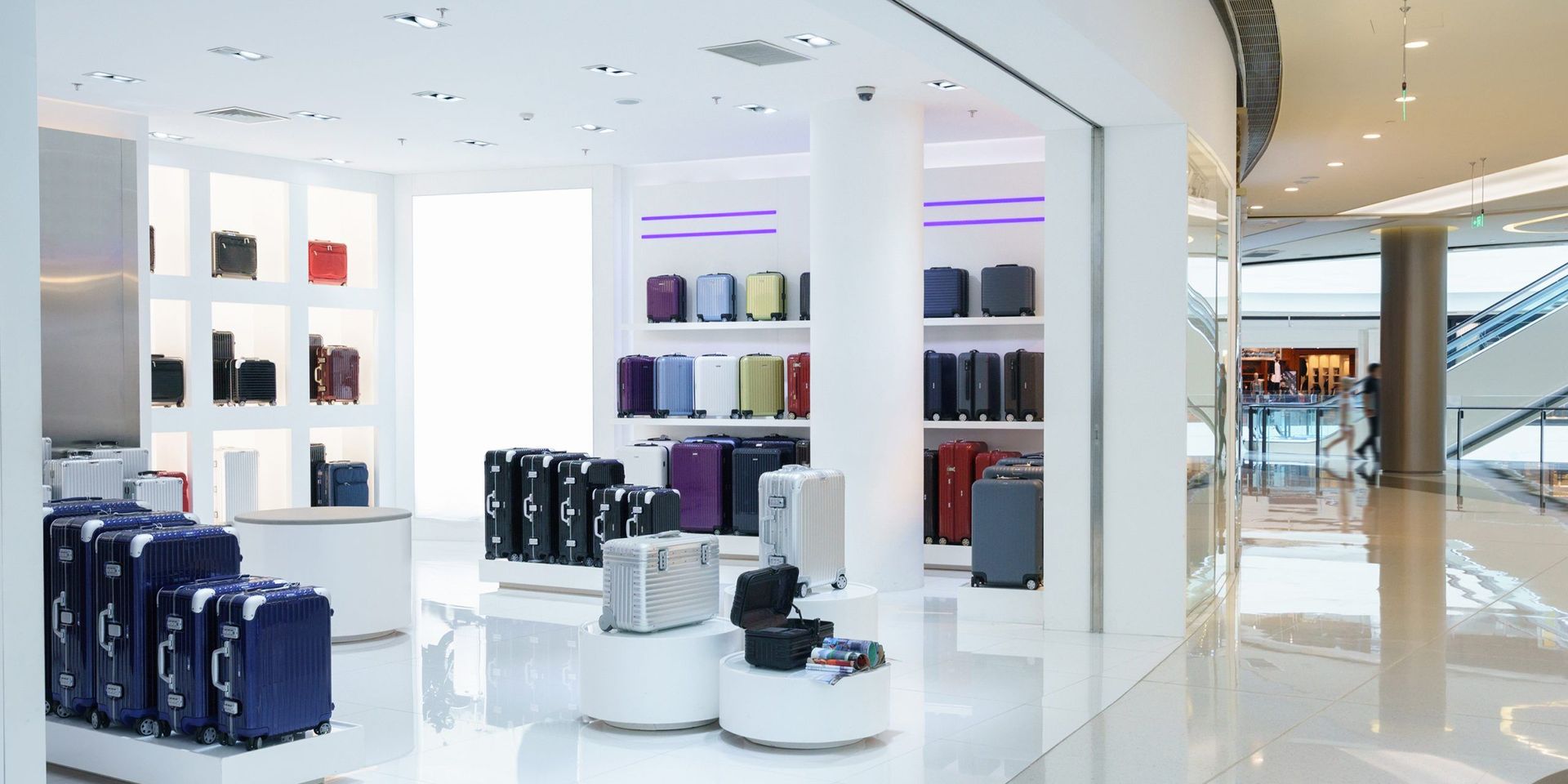 Inside a luggage store with displays of suitcases and a bright white interior.