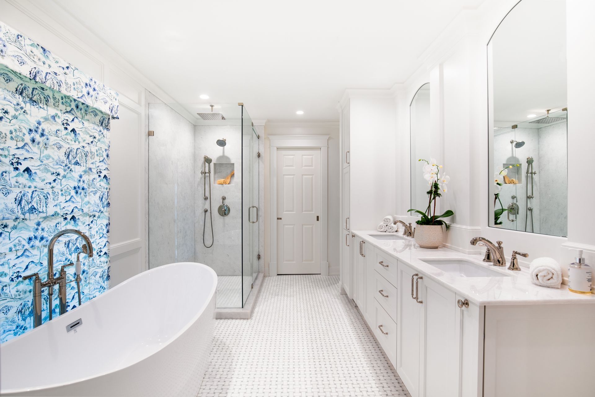 Bright white bathroom with a freestanding tub, glass shower, and blue accent wall. Highland Park bathroom renovation