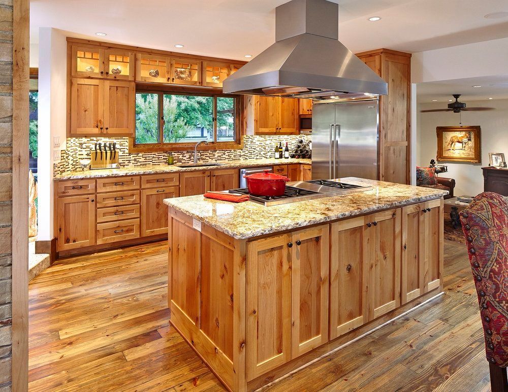 Wooden kitchen with island, stainless steel appliances, and granite countertops. Northwood Hills exterior renovation.
