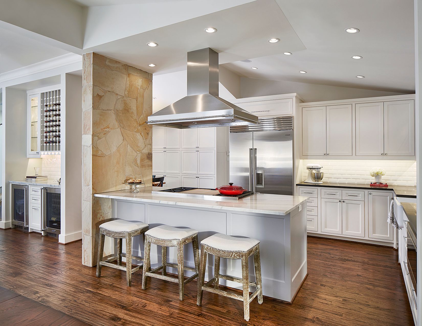 Modern kitchen with white cabinets, island with stools, stainless steel hood, Highland Park kitchen Renovation.