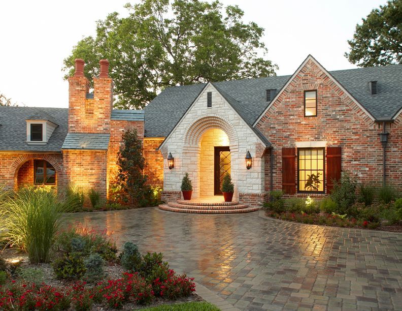 Brick house with stone archway entrance, lit driveway, and landscaping. Lake Highlands exterior renovation.