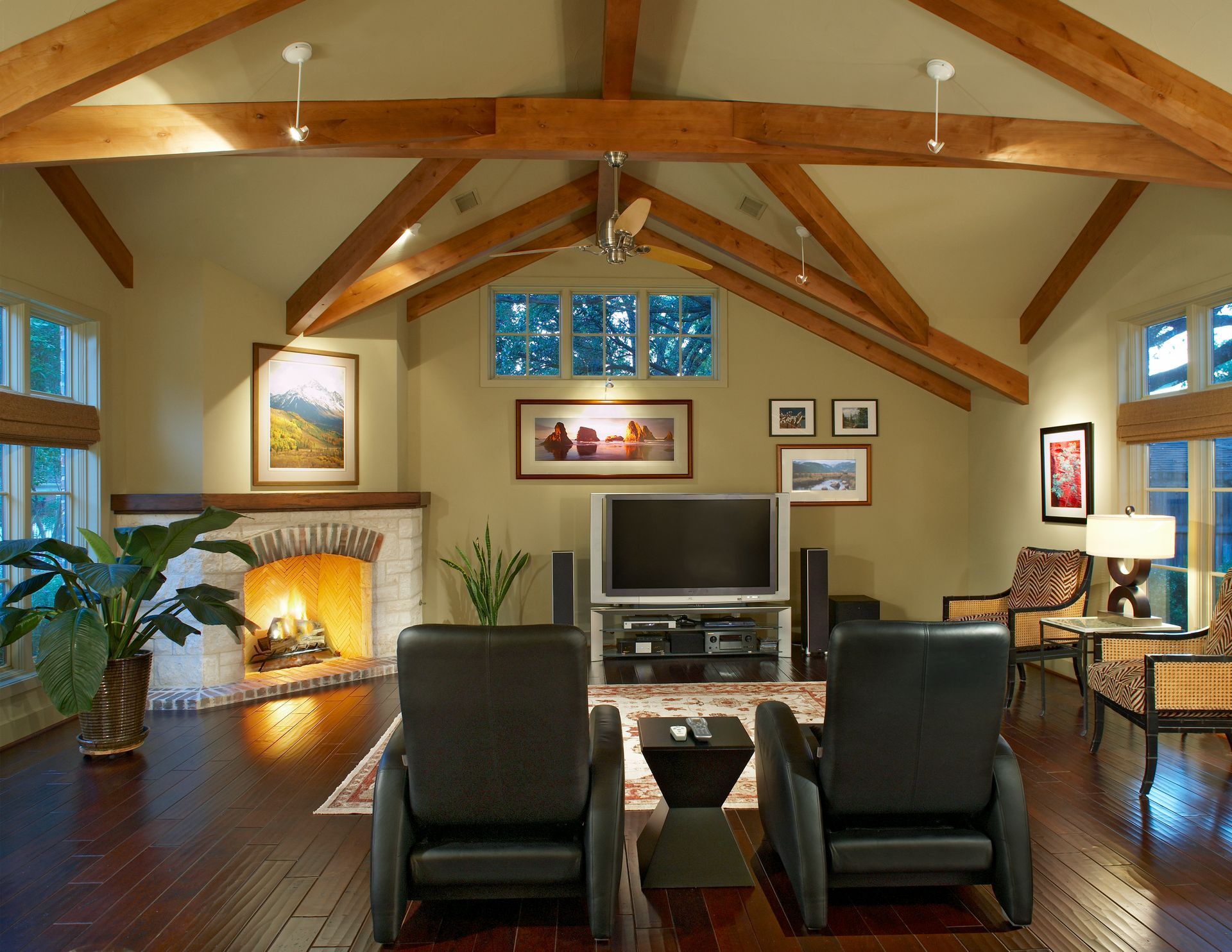 Living room with dark wood floors, fireplace, wood beams, and two black recliners. Richardson Living room renovation