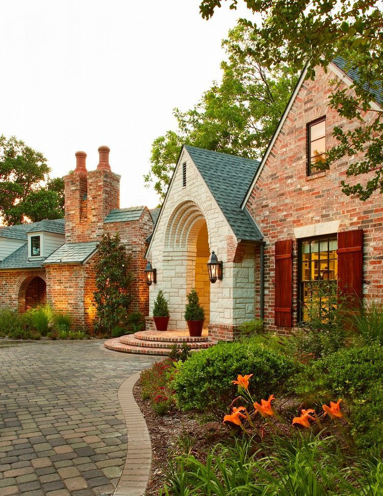 Brick house with arched entrance, chimney, and brick paved driveway; Lakewood Neighborhood Renovation