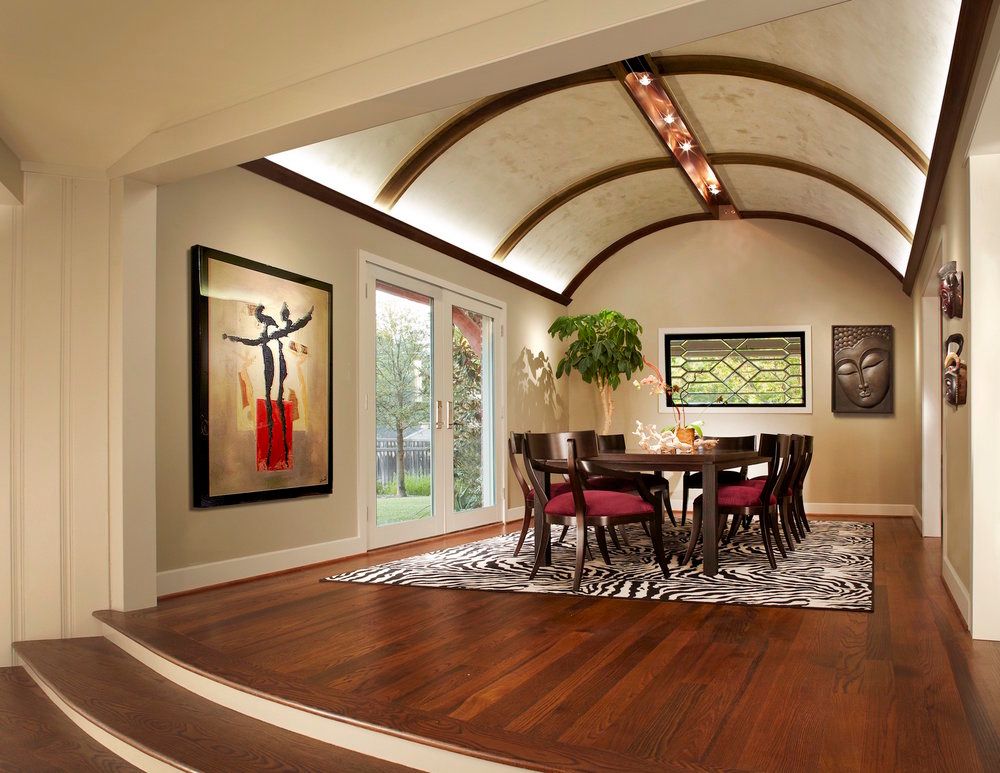 Dining room with dark wood table and chairs, ornate ceiling, artwork, and French doors. Plano dining room renovation.