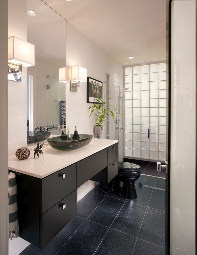 Modern black and white bathroom with a floating vanity, glass block shower, and dark tile floor. University Park bathroom.