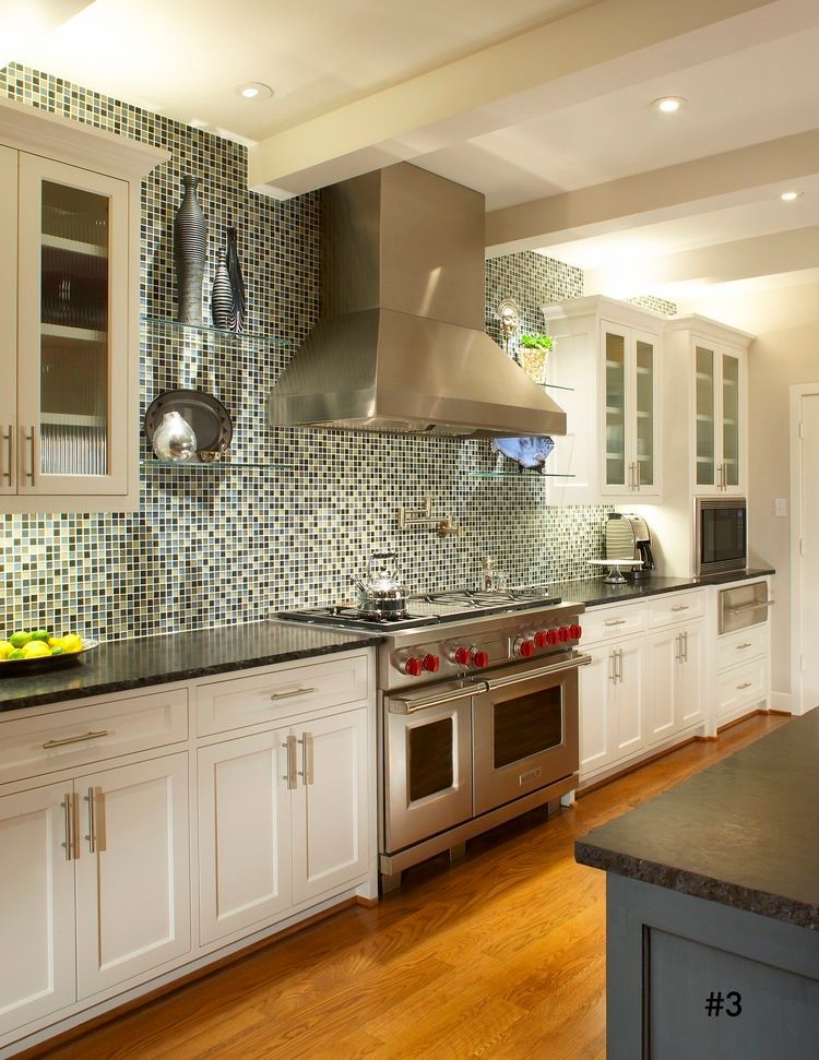 Kitchen with white cabinets, stainless steel appliances, and mosaic backsplash.
