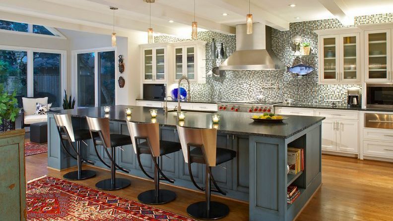 Spacious kitchen with blue island, stainless steel appliances, and white cabinets.