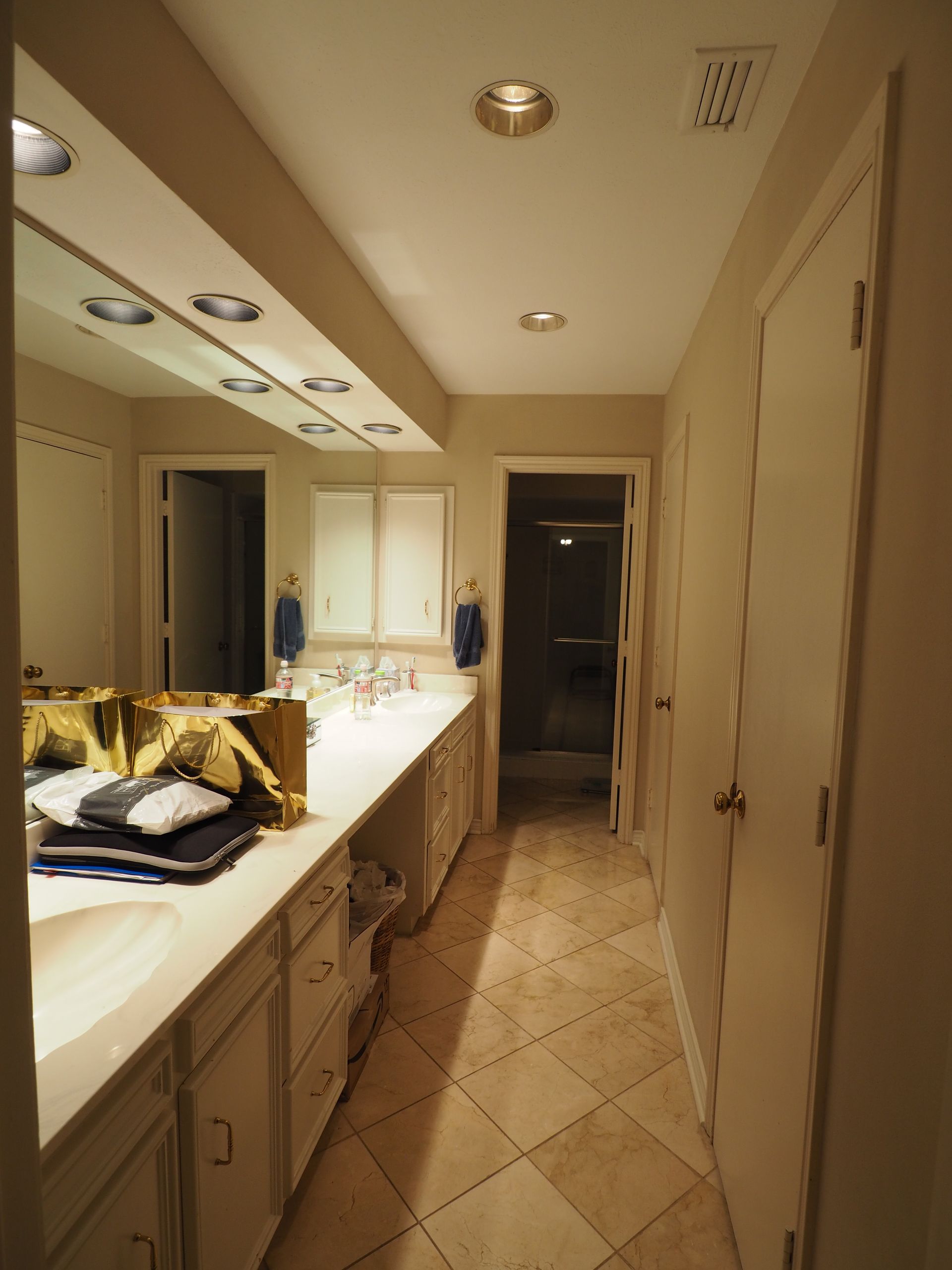 A living room with wooden floors, a stone fireplace, built-in cabinets, two wingback chairs, and an area rug.