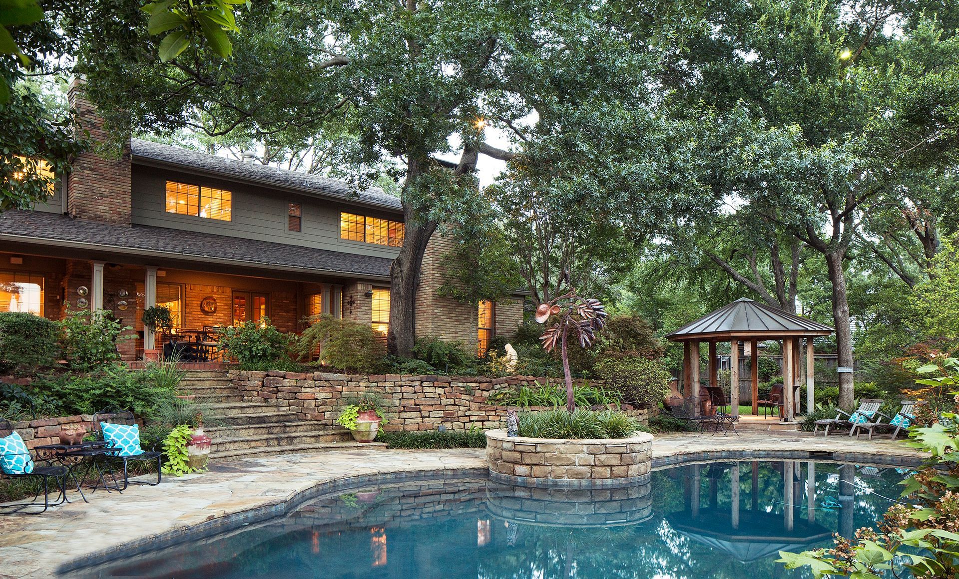 A two-story house with a pool and a gazebo, surrounded by trees and greenery. Highland Park Exterior Renovation