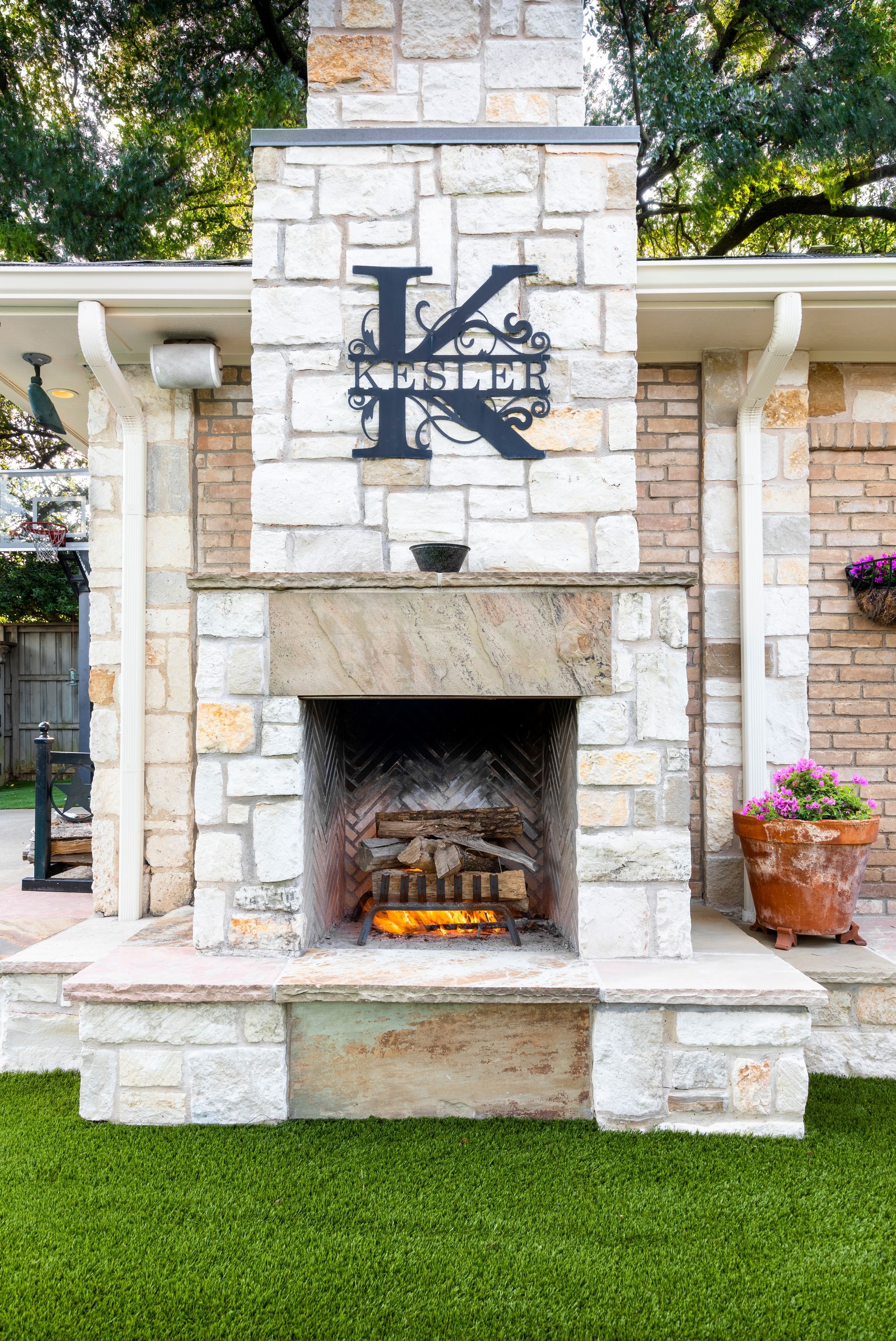Outdoor stone fireplace with a large metal letter 