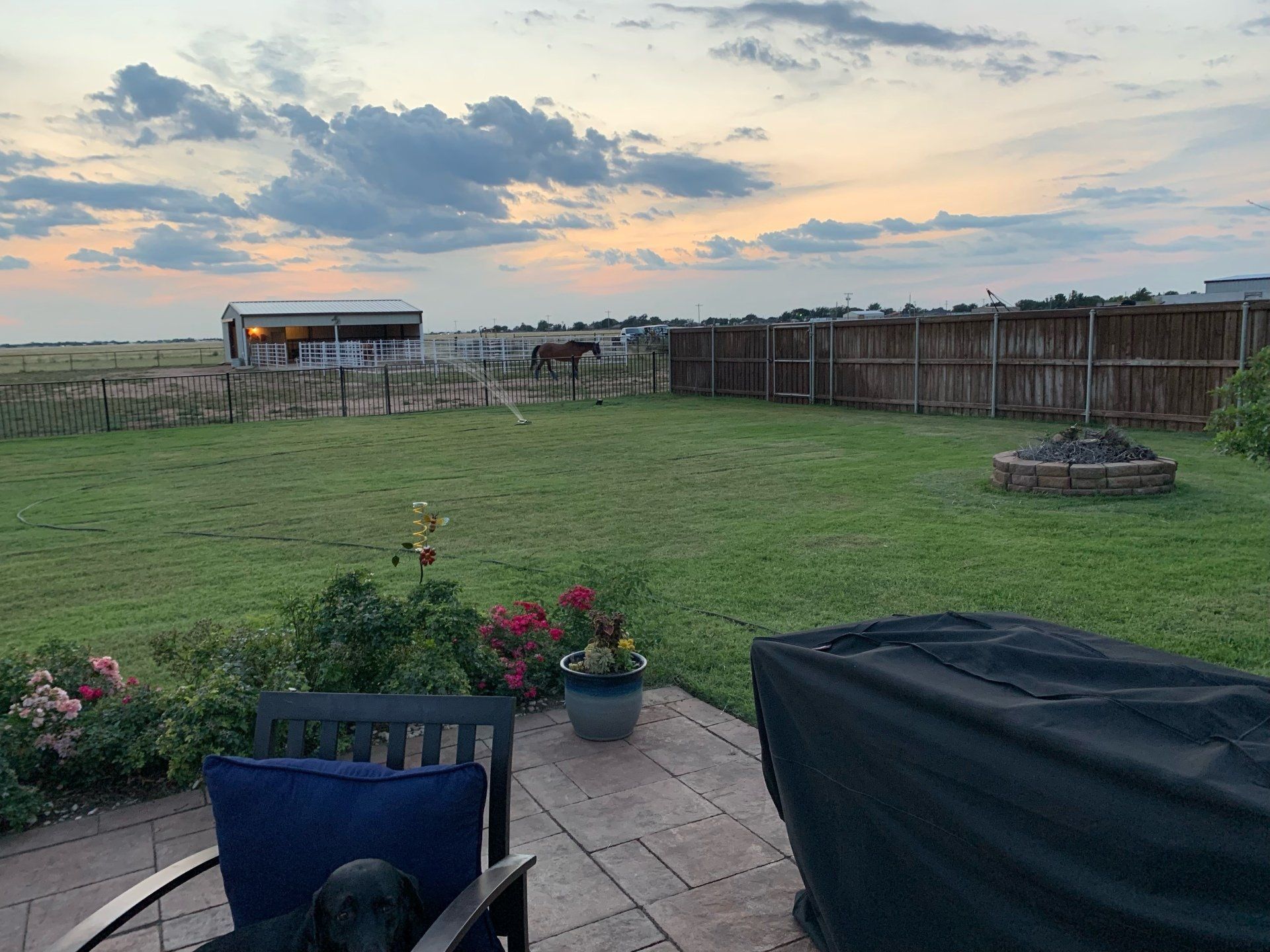 A patio with a chair and a fire pit in the backyard.