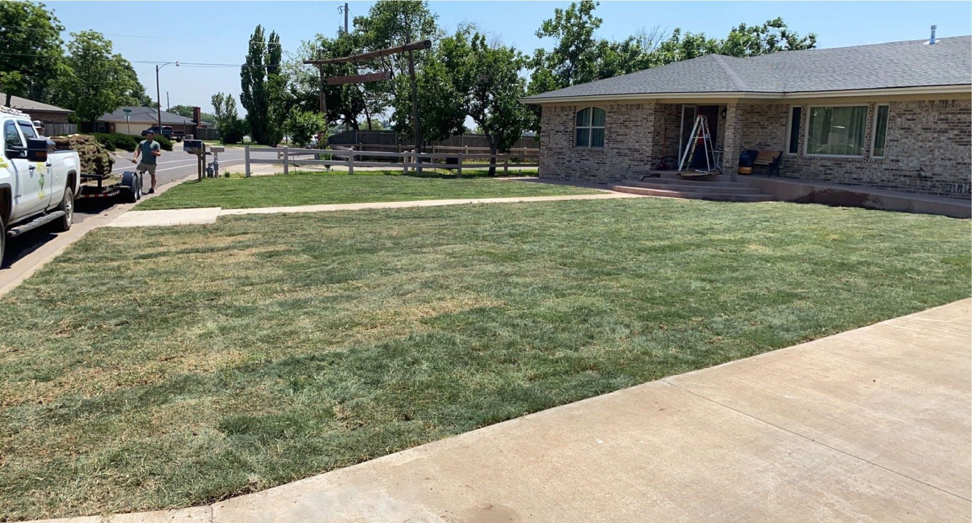A truck is parked in front of a house with a lush green lawn.