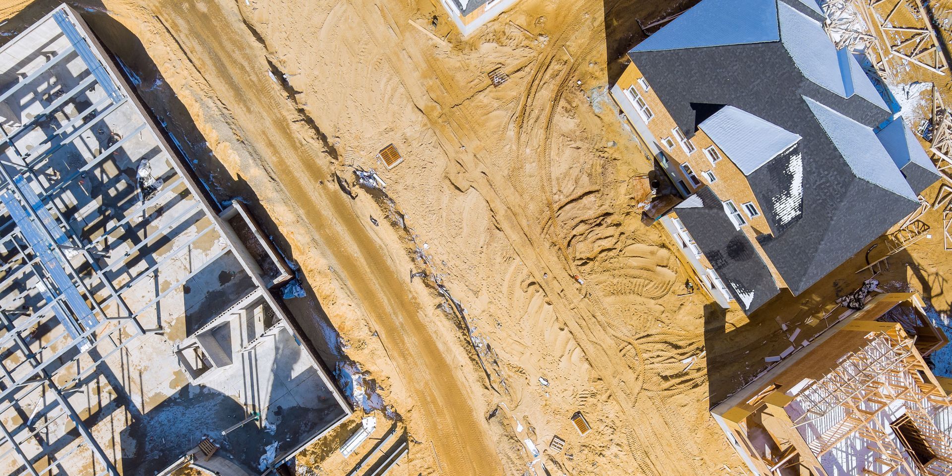 An aerial view of a house under construction on a dirt road.