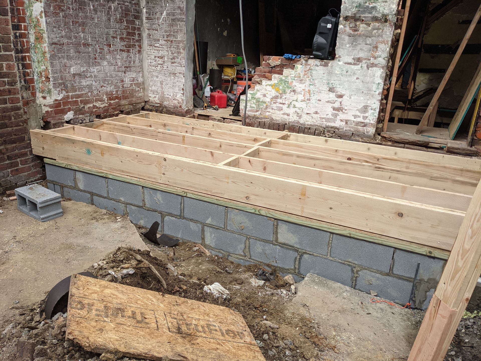 A wooden floor is being built in front of a brick building.