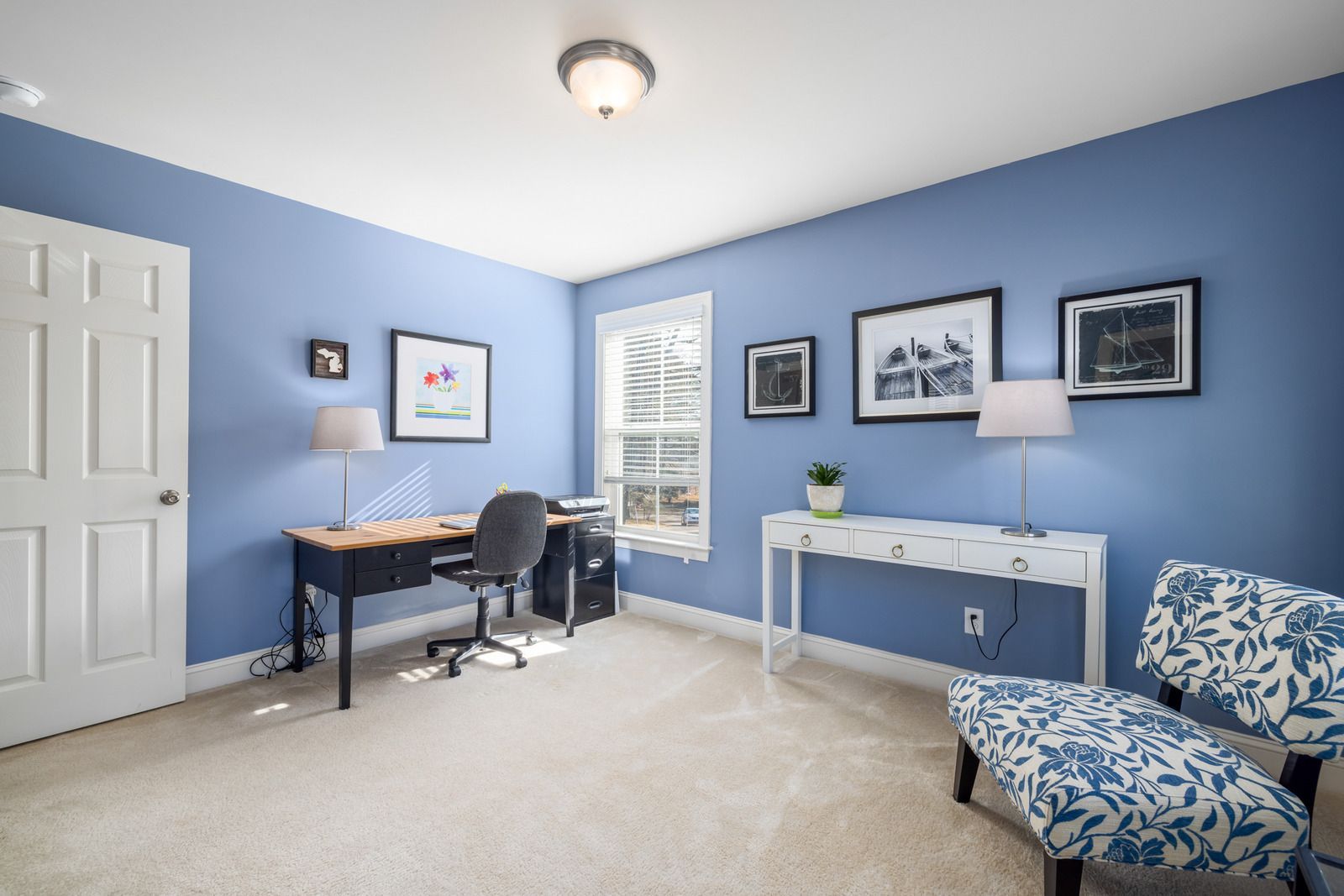 Empty living room with fireplace, windows, and light wood-look flooring. White walls and trim.