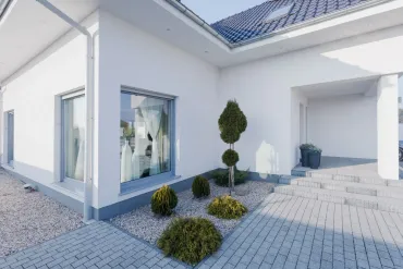 White house exterior with small garden and gray paved walkway.