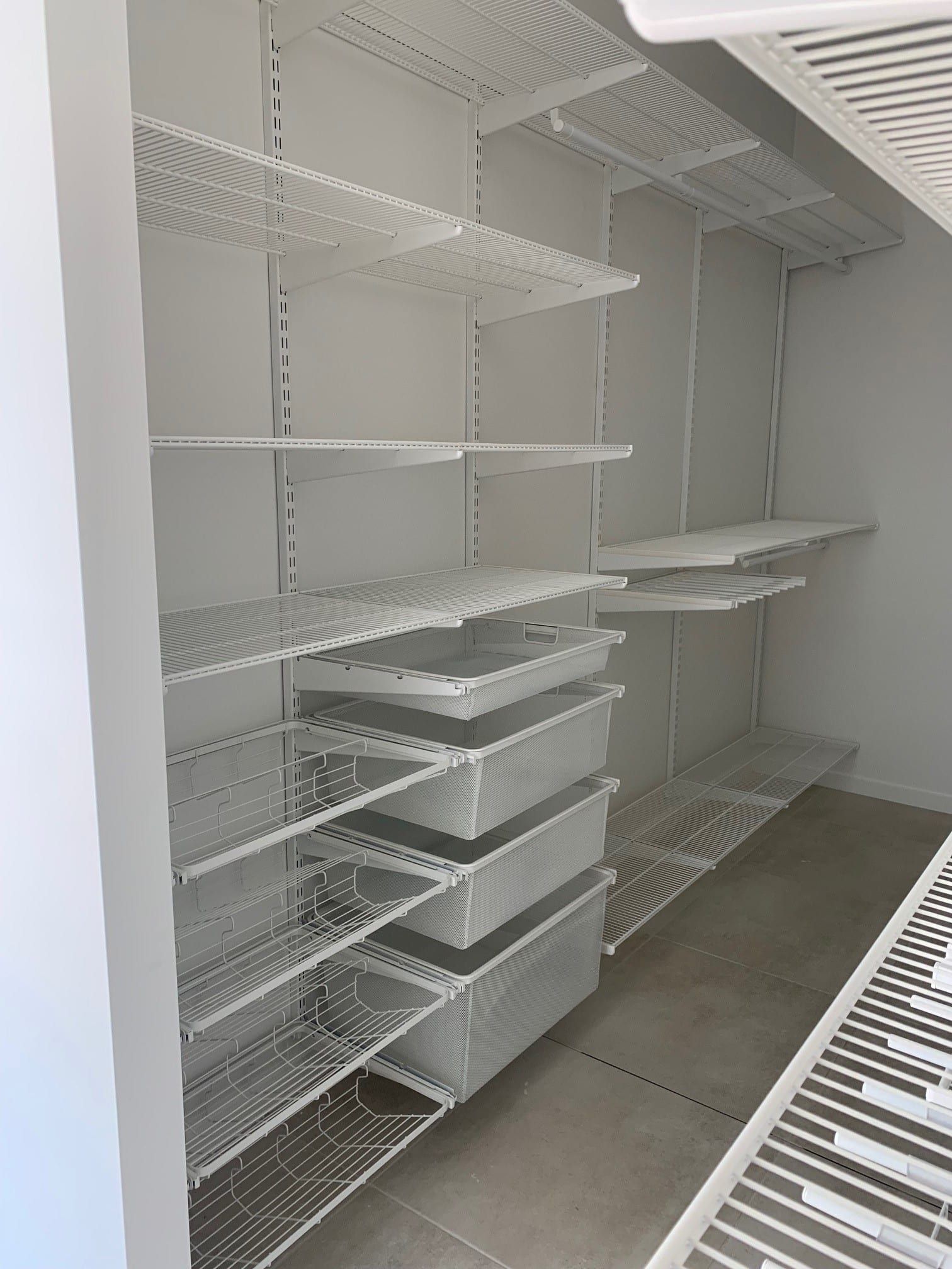 White wire shelving in a closet, with adjustable shelves and pull-out baskets.— Ezyshelf in Rockhampton, QLD