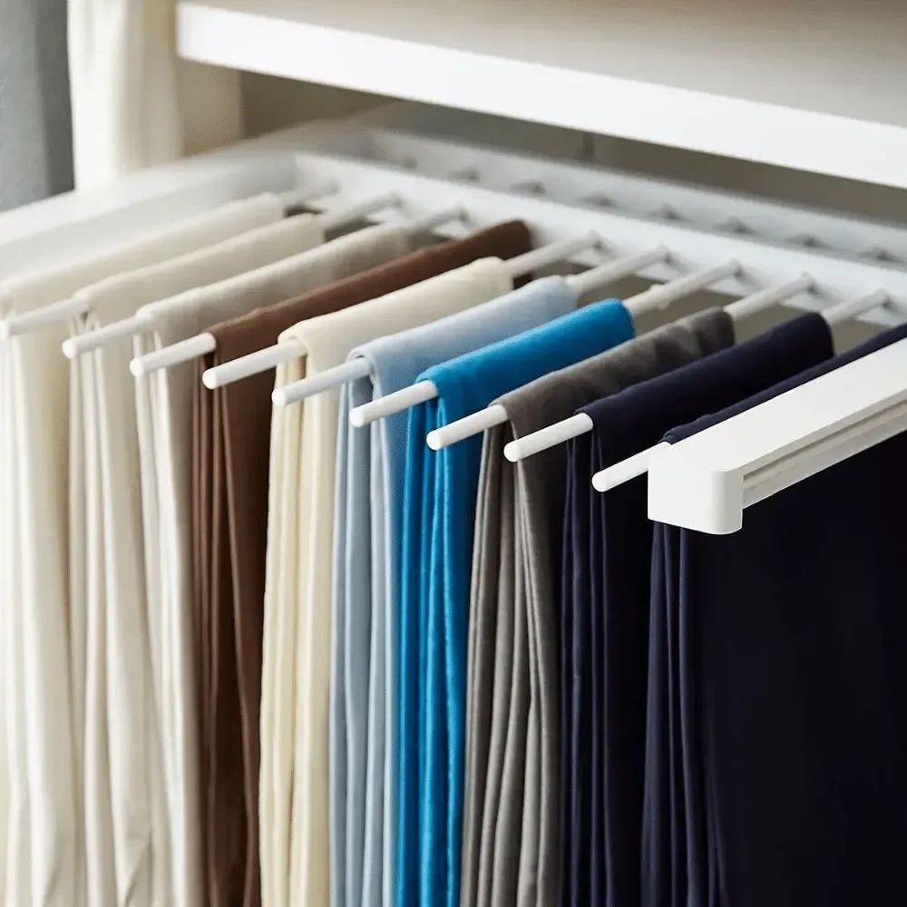 Pants hanging neatly in a white closet organizer. Various colors, including blue, brown, and cream, are visible.— Ezyshelf in Townsville, QLD 