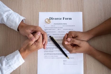 a man and woman's hands folded across a document that reads 