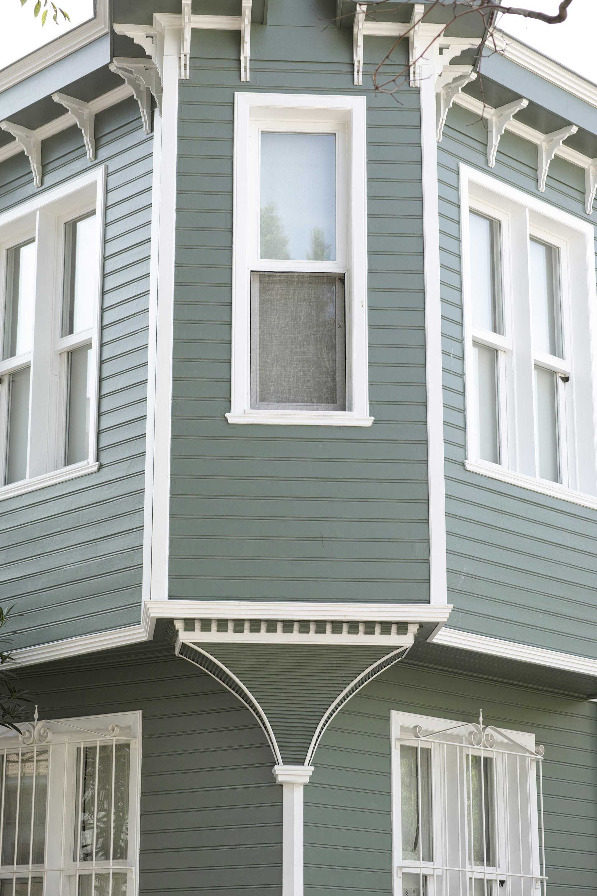 A green house with white trim and windows