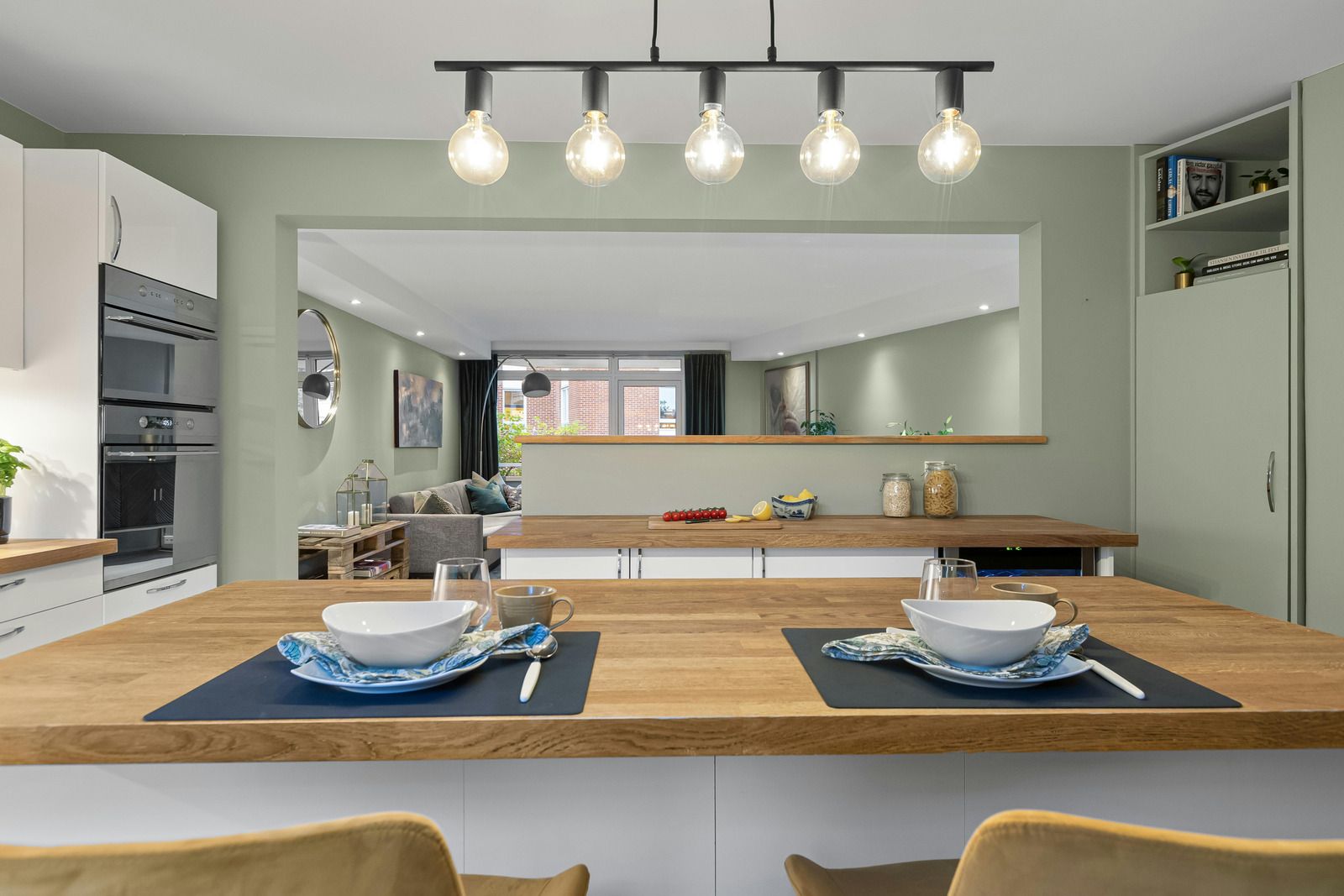 A kitchen with a wooden counter top and two bowls on it.