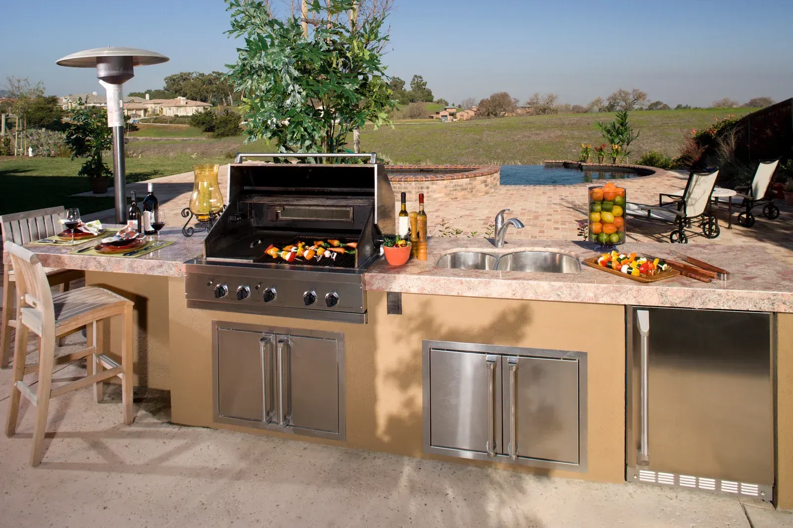 An outdoor kitchen with a grill and a sink
