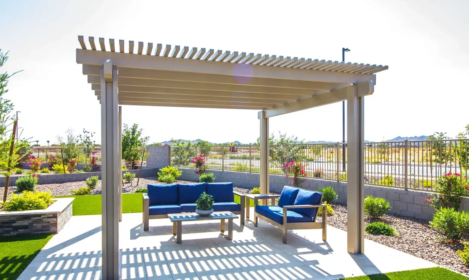 A pergola with a couch and chairs underneath it