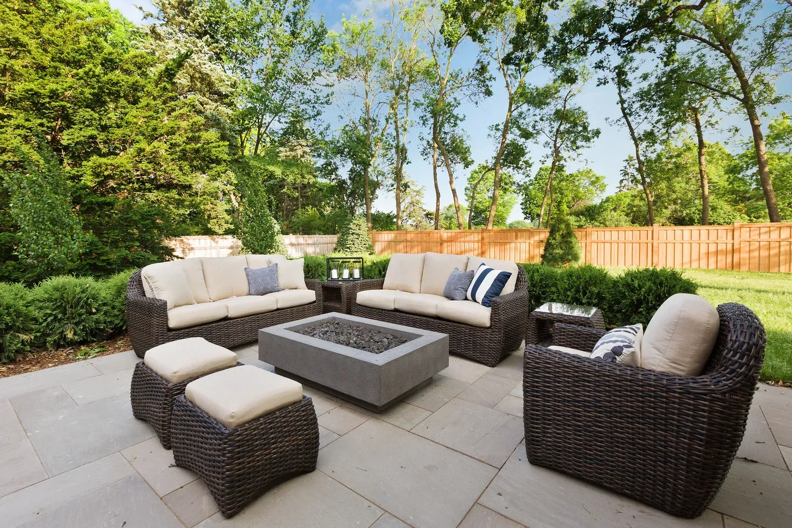 A patio with wicker furniture and a fire pit.