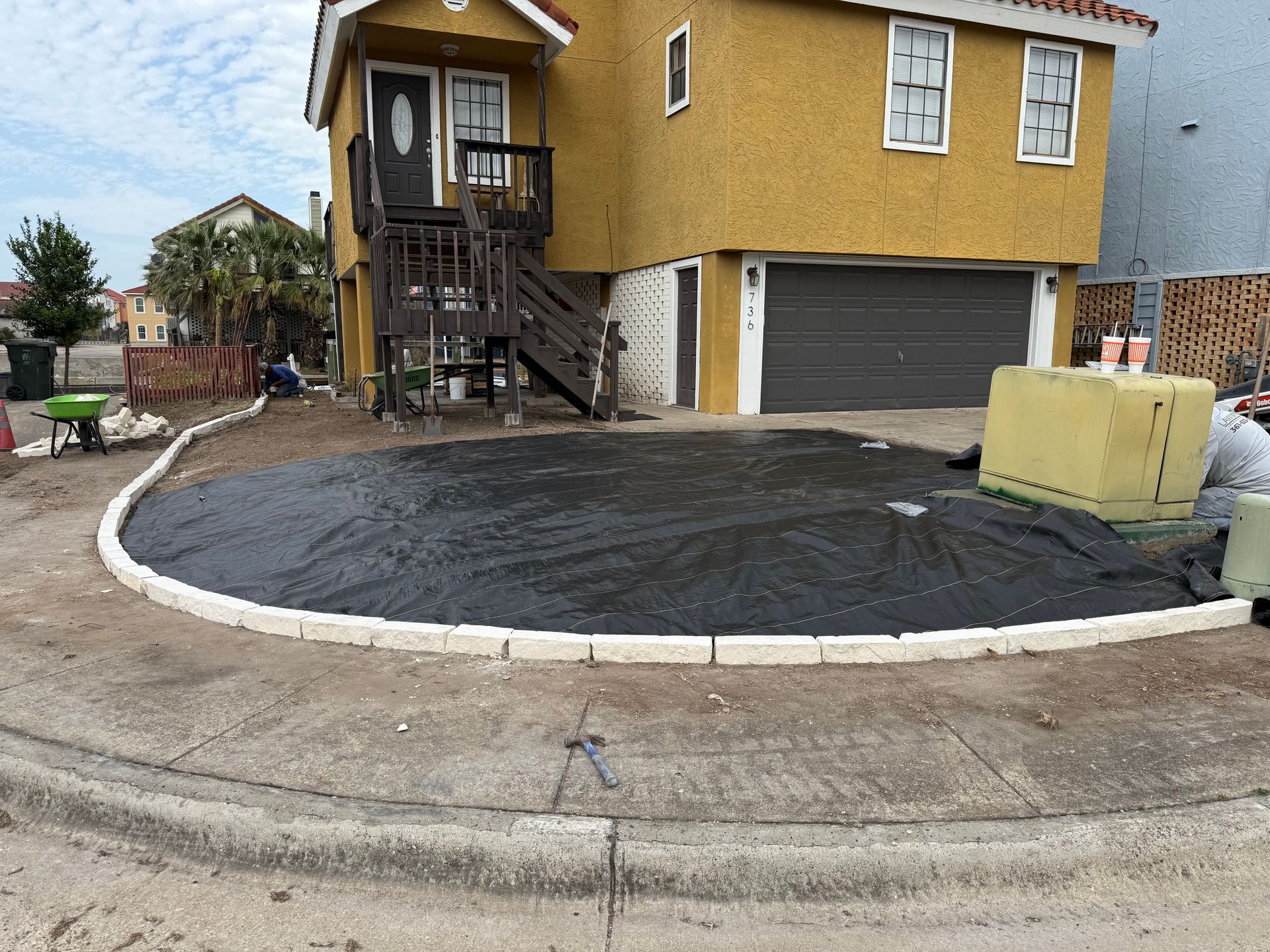 A yellow house with a circular driveway in front of it.
