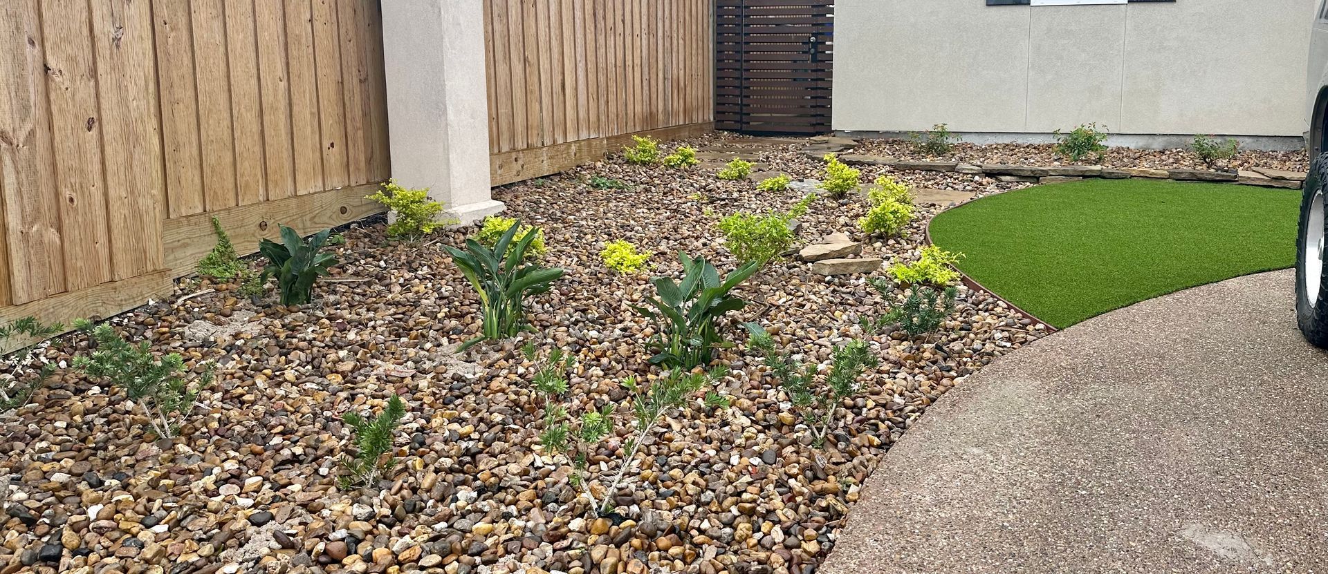 A car is parked in a driveway next to a fence.