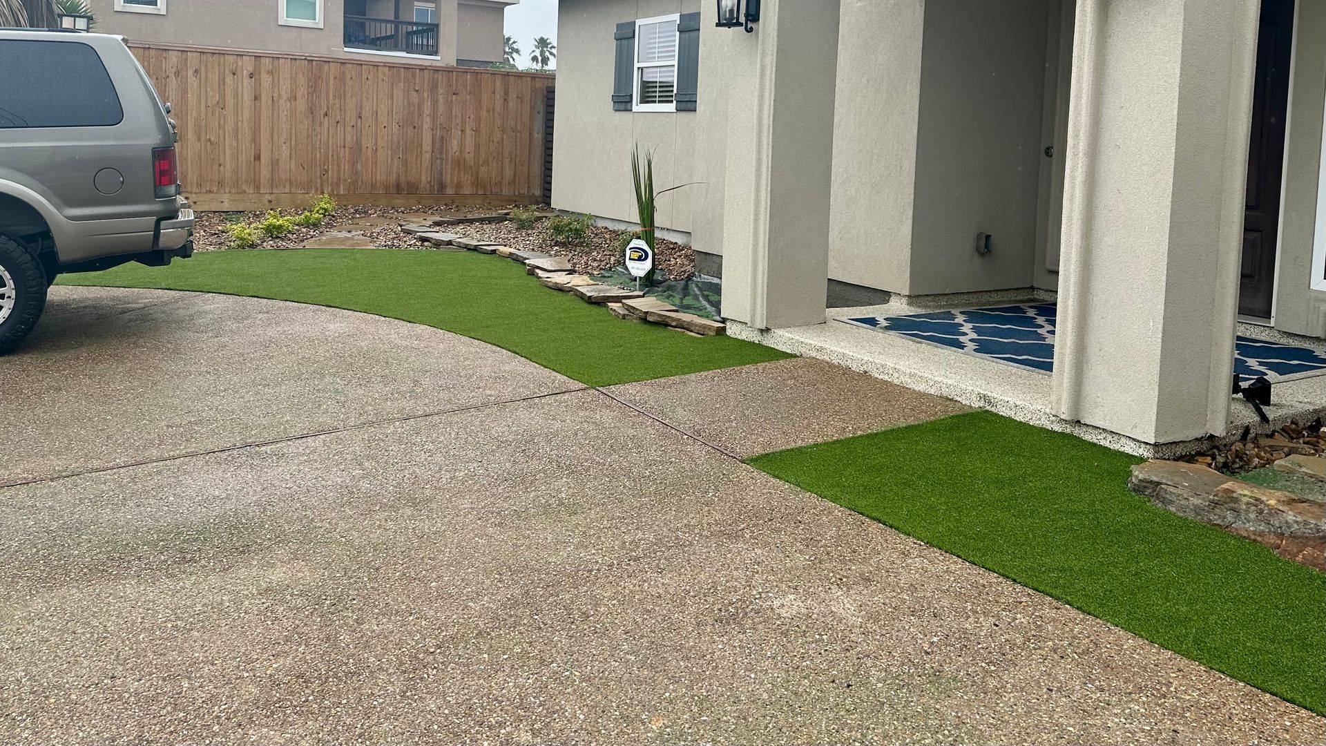 A car is parked in a driveway next to a house.