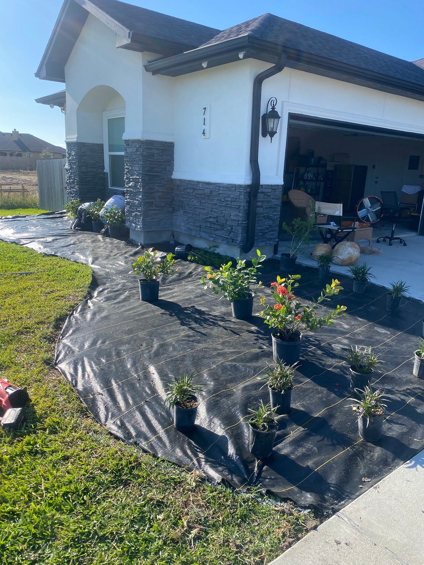 A house with a lot of potted plants in front of it.