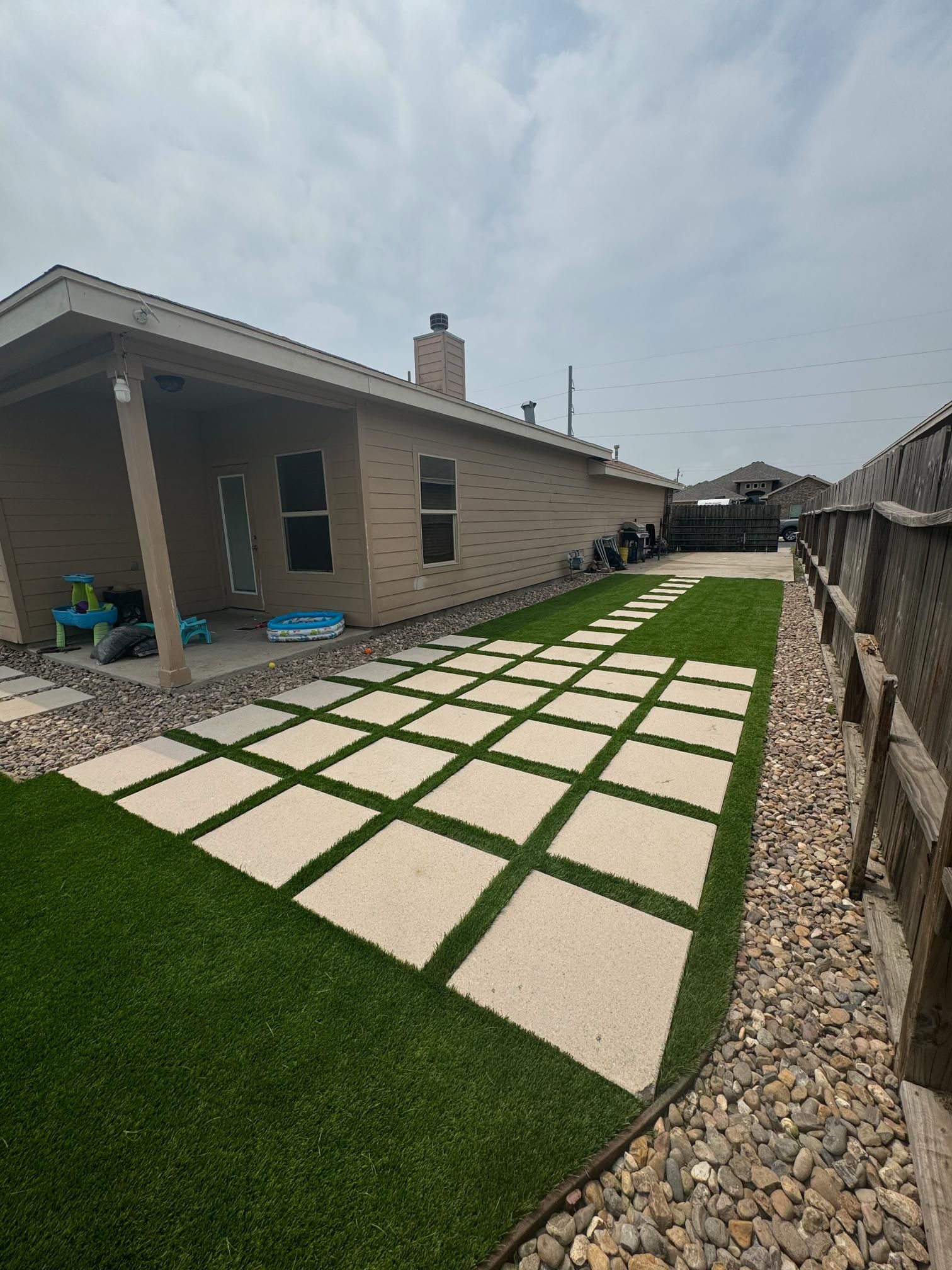 A house with a fence and a walkway in front of it.