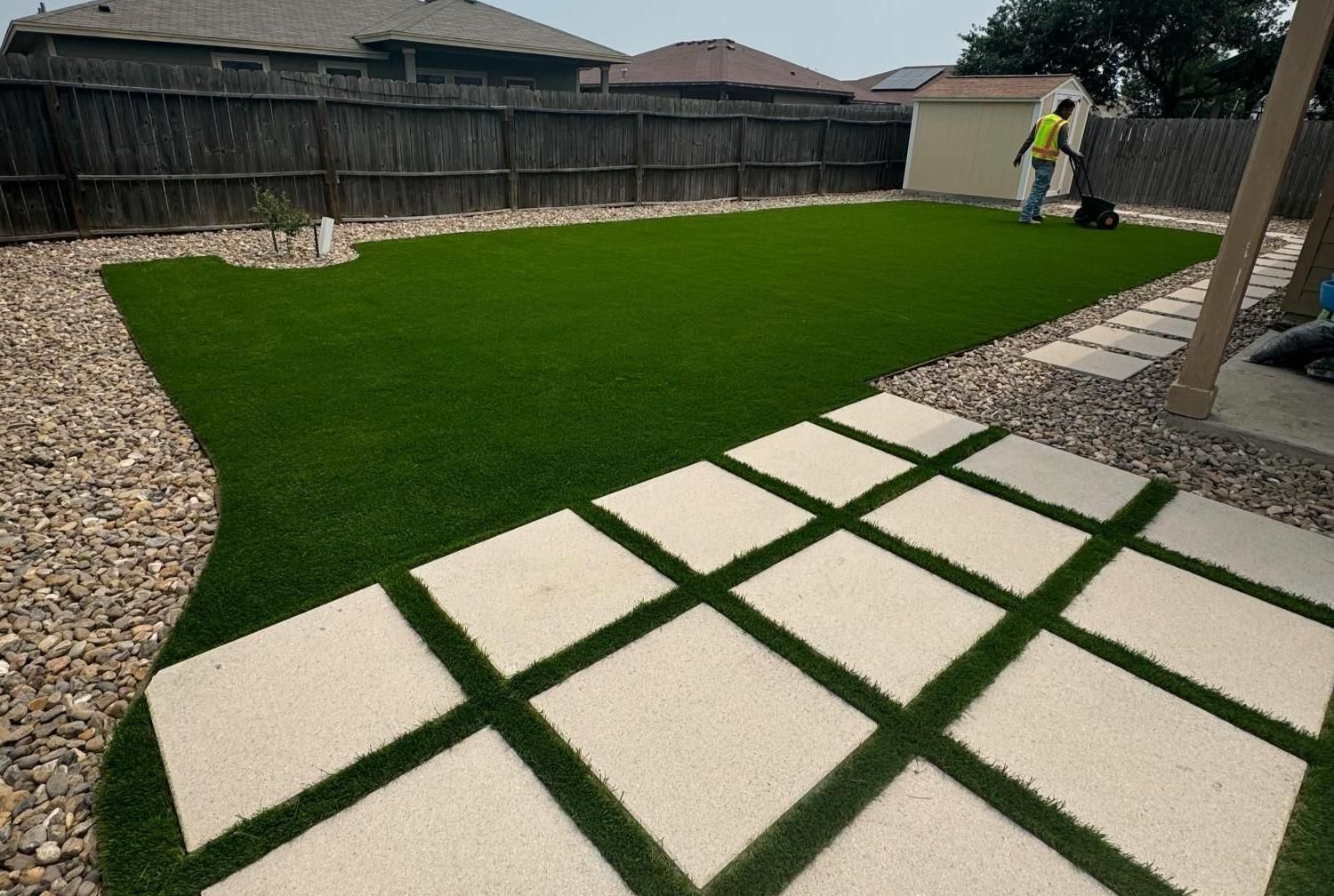 A man is adding infill material to turf