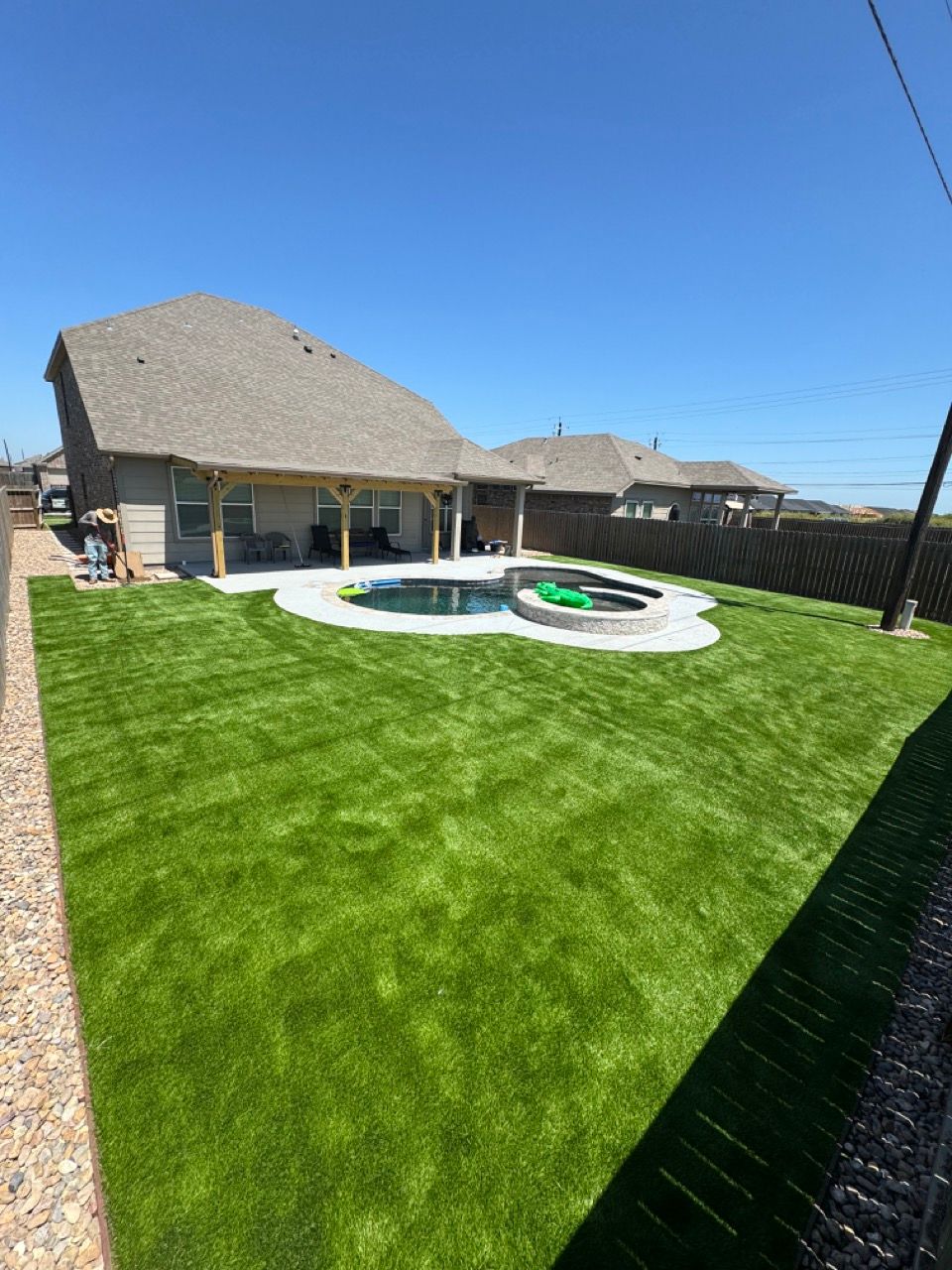 A backyard with a swimming pool and a house in the background.