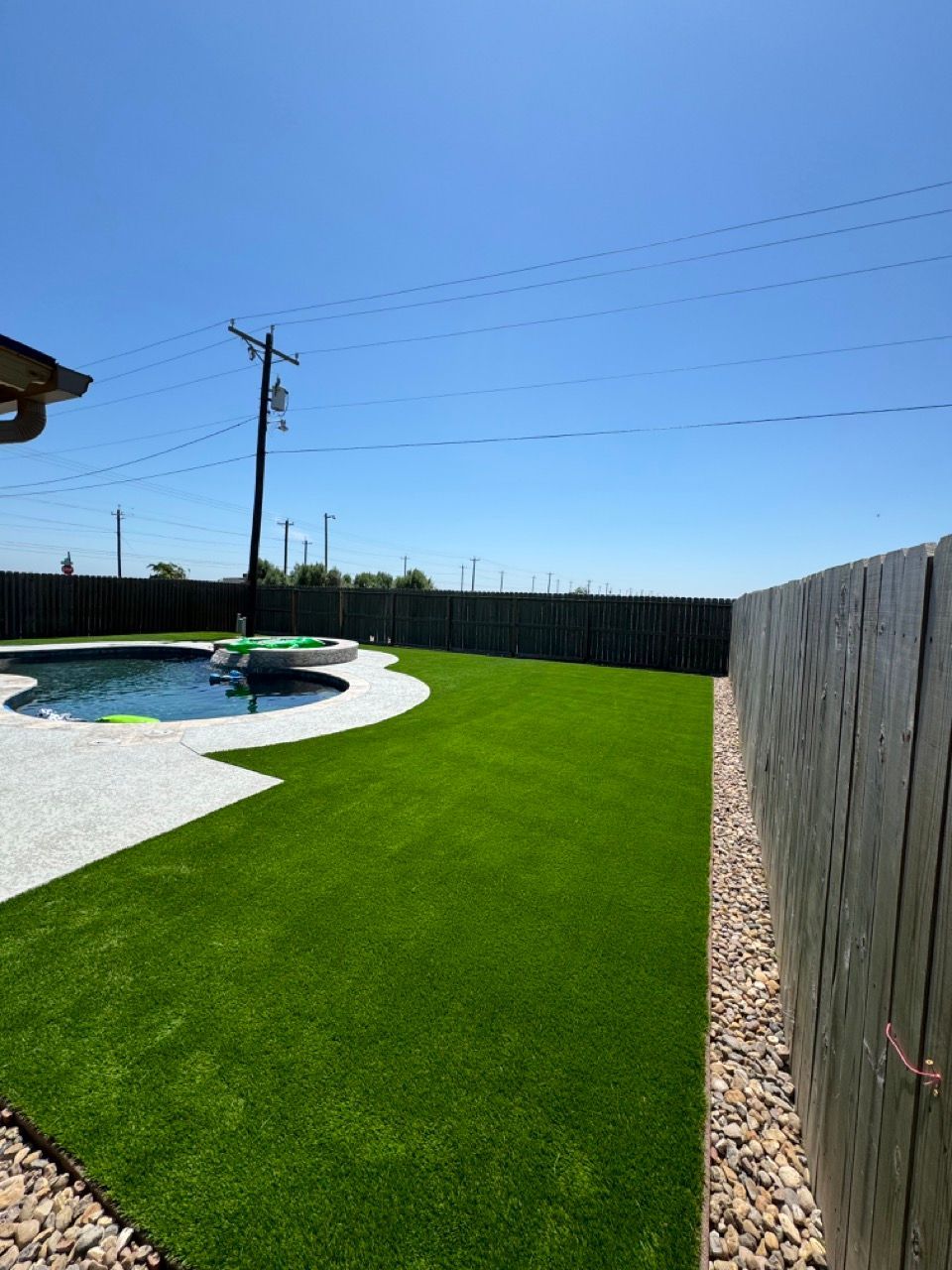 A backyard with a fence and a swimming pool